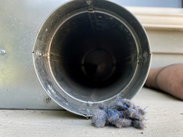 Raynham Dryer Vent Cleaning technician using specialized equipment to clear severe dryer vent blockage in Raynham